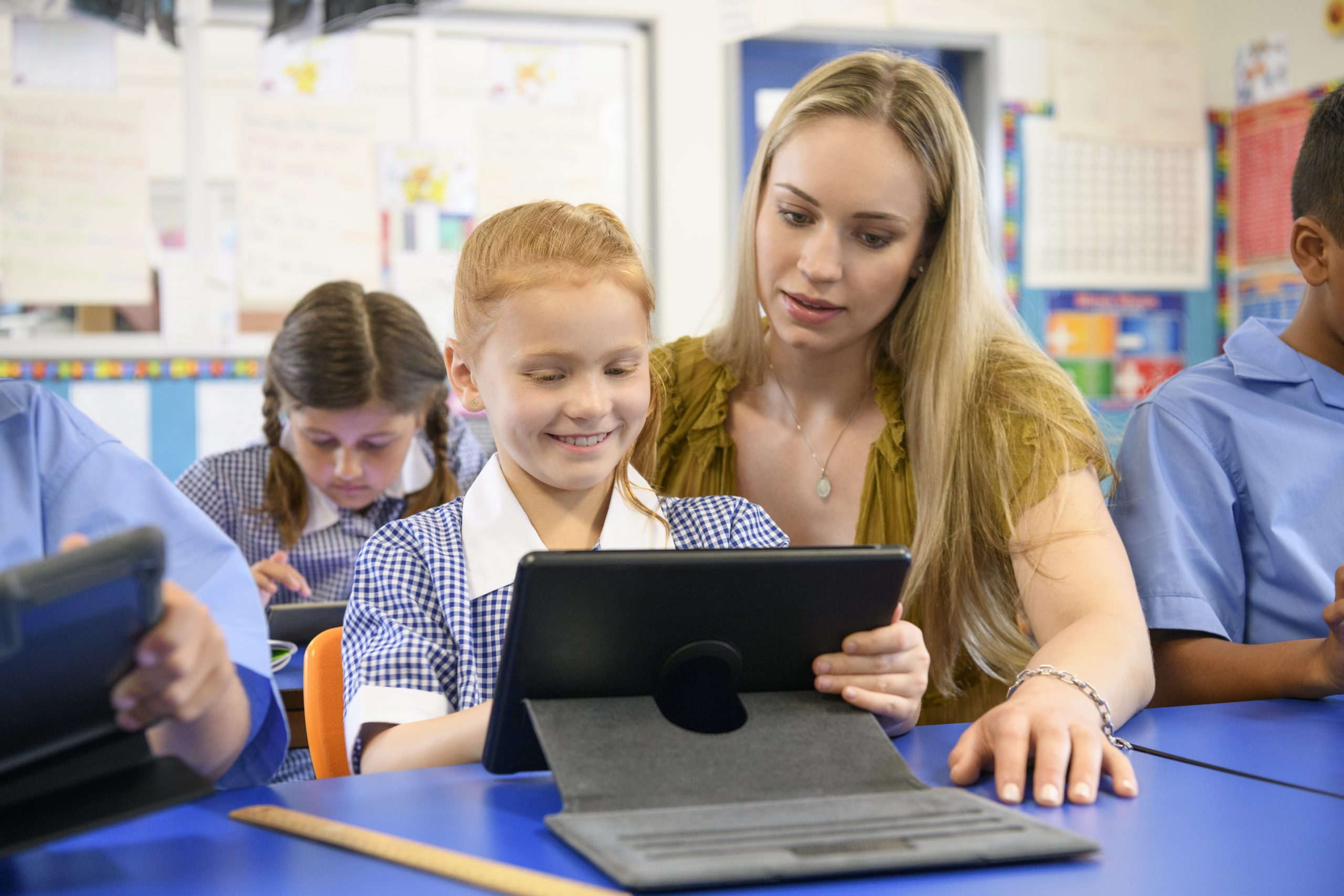 An image of an education support worker helping a young student with his homework